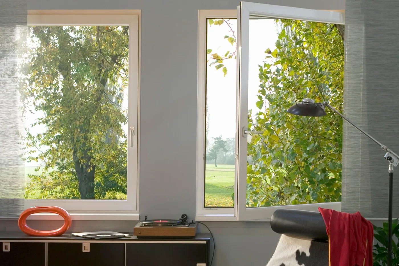 Weiße GEALAN S 8000 Kunststofffenster in einem hellen Wohnraum mit Blick in den Garten