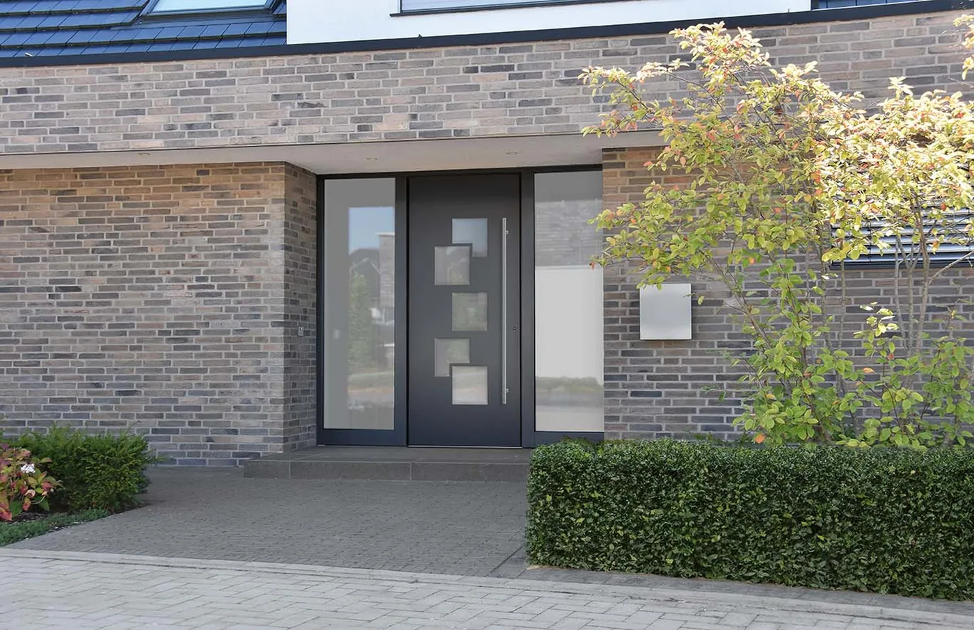 Haustür mit Glas-Seitenteilen links und rechts an einem Klinkerhaus