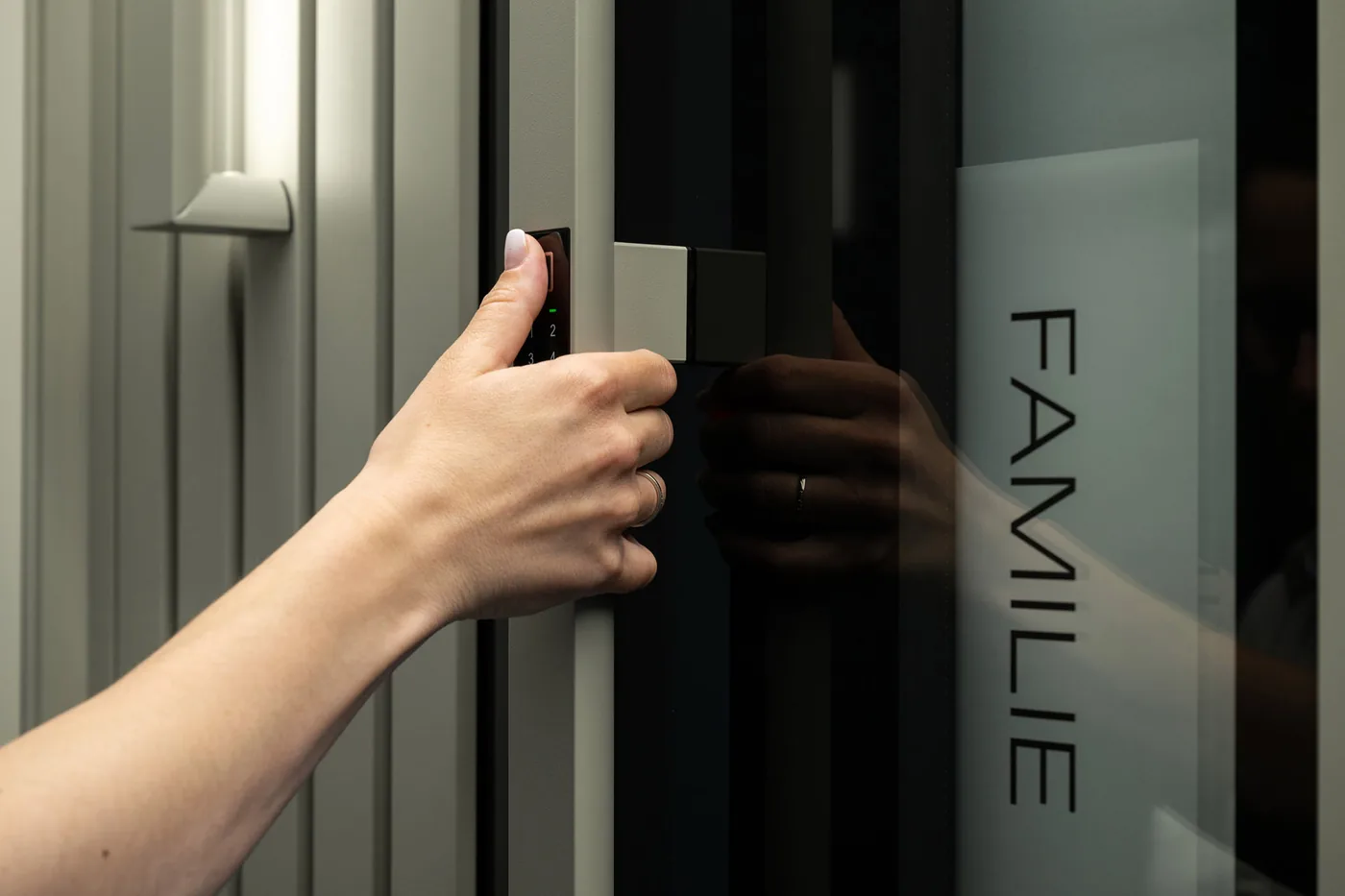 Finger auf dem Fingerabdrucksensor neben der Haustür